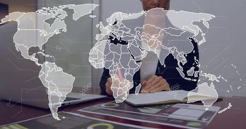 Businesswoman writing notes and analyzing global charts on laptop with world map overlay