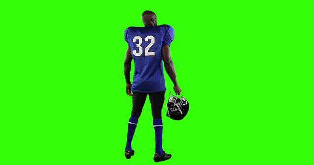 An American football player holding his helmet with a reflective stance. This image features a player wearing a full uniform, including jersey number 32, standing against a green background. Use this image for sports promotions, athletic-themed advertisements, or fitness and exercise content. The green background can be easily replaced or edited for custom designs.