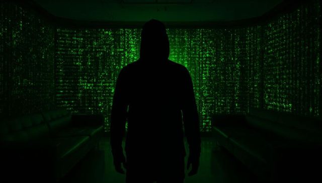 Hooded silhouette facing green code projection in neon cyber lounge with reflective floor
