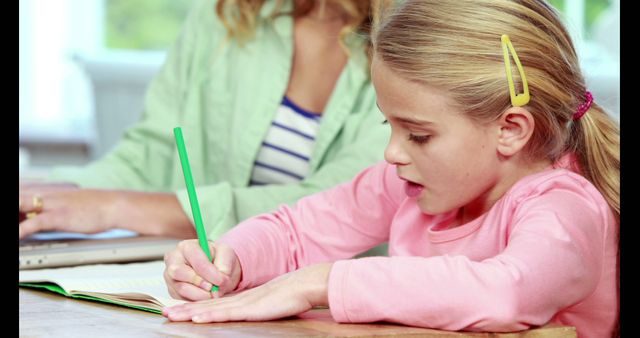 Young Girl Writing While Sitting at Table with Adult - Download Free Stock Images Pikwizard.com