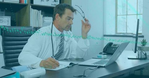 Male Doctor Writing Notes in Modern Medical Office