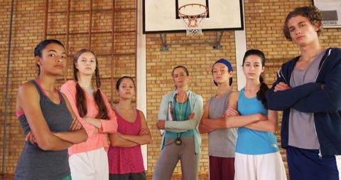Confident Teenage Basketball Team and Coach in School Gym