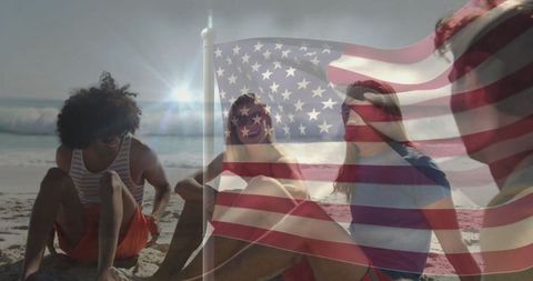 Friends Relaxing on Beach with American Flag Overlay at Sunset