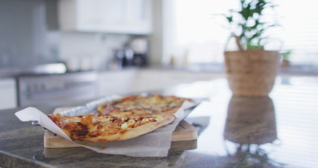 Image of homemade cooked pizza on paper and baking tray on kitchen counter. Cooking and lifestyle concept.