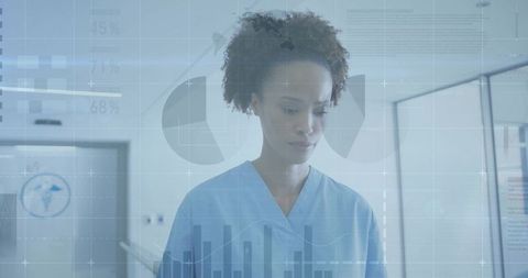 Clinician reviewing digital healthcare analytics dashboard in hospital corridor