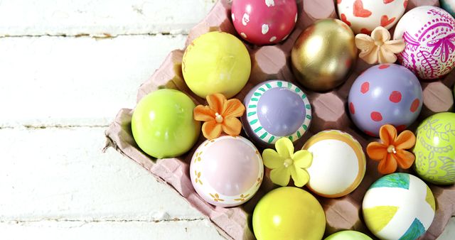 Colorful Easter eggs with various patterns and designs are arranged in a carton, with copy space. These eggs symbolize the celebration of Easter and the tradition of egg decoration.