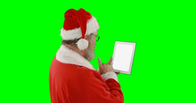 Santa Claus using tablet with green background - Download Free Stock Images Pikwizard.com