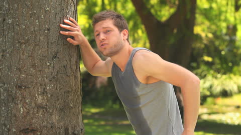 Exhausted Jogger Resting Against Tree