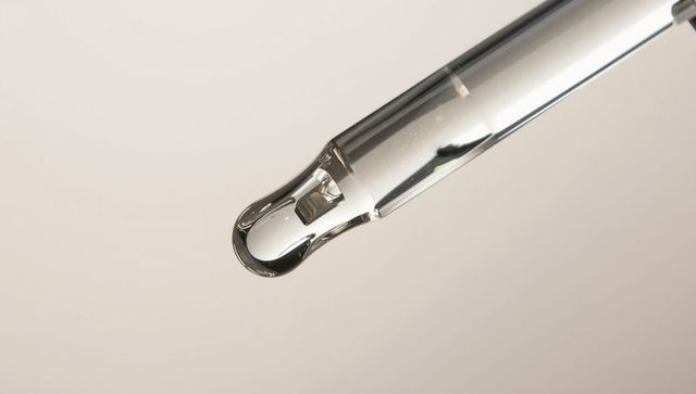 Close-up of Glass Dropper Pipette with Clear Liquid Droplet