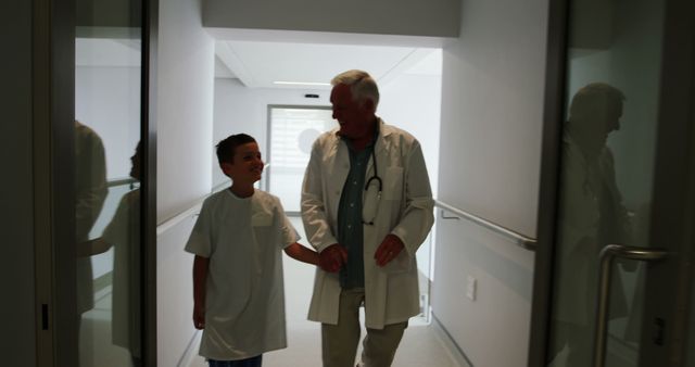 Doctor and young patient walking in hospital hallway - Download Free Stock Images Pikwizard.com