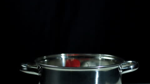 Scotch Bonnet Chili Falling into Stainless Steel Pot in Slow Motion