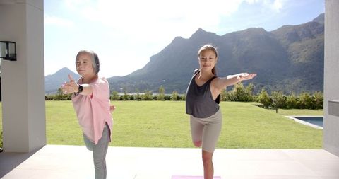 Grandmother and Granddaughter Practicing Yoga Outdoors