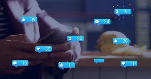 Hands holding smartphone and tapping with social media notifications floating over cafe