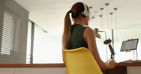 Content creator with headphones recording in modern home office