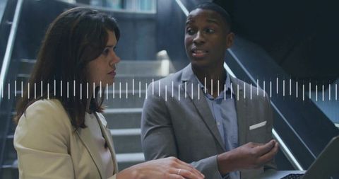 Professional business discussion in office setting with laptop