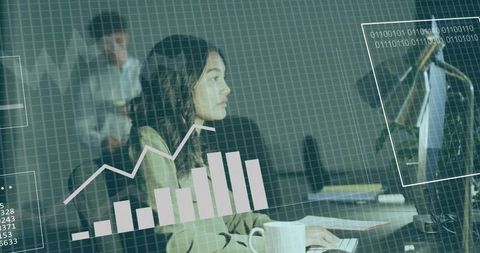 Working woman analyzing digital analytics dashboard while typing at office desk