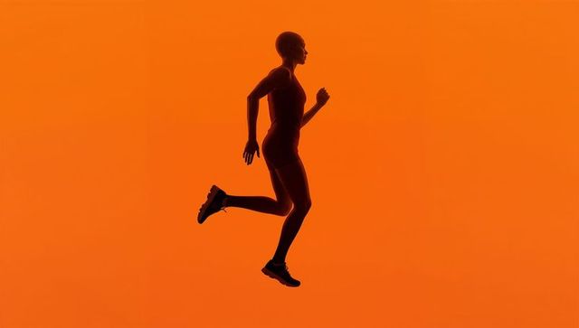 Silhouette of Athletic Runner in Mid-Leap Against Vibrant Orange Background