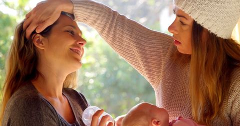 Loving Interaction Between Mother and Daughter with Newborn Baby