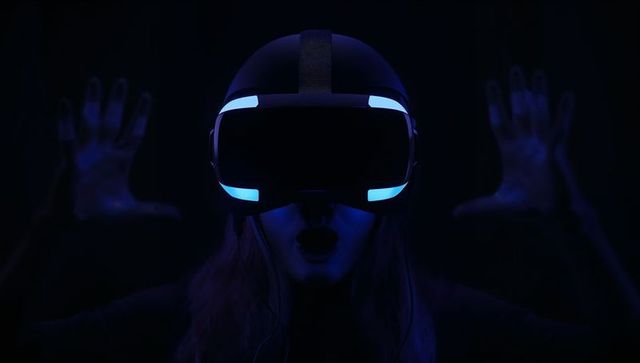 Woman Experiencing Virtual Reality Awe Wearing Illuminated VR Headset in Dark Neon Blue