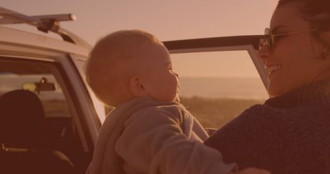 Mother and Baby Enjoying Sunset by Car