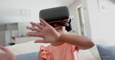 Joyful Girl Immersed in Virtual Reality at Home