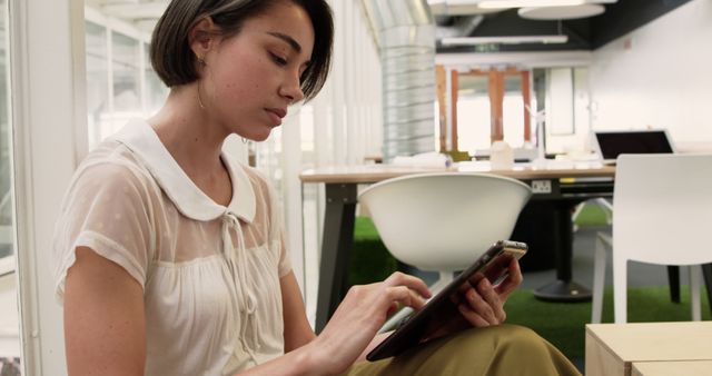 Focused Young Woman Using Digital Tablet in Modern Office - Download Free Stock Images Pikwizard.com