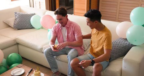Gay Couple Celebrating Birthday with Gift on Sofa