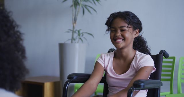 African american girl smiling while sitting on a wheelchair at hospital. healthcare and medical concept