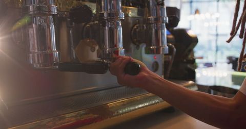 Barista brewing espresso in modern cafe using coffee machine