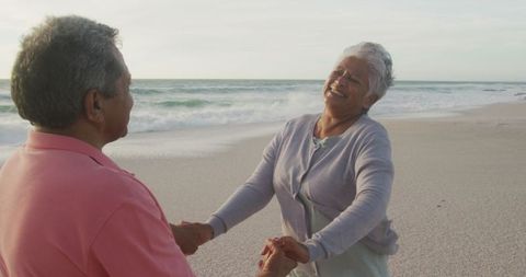 Joyful Retired Couple Dancing on Sunset Beach