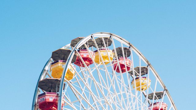 Colorful Ferris Wheel Against Blue Sky at Amusement Park - Download Free Stock Photos Pikwizard.com