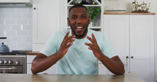 Man Sitting at Kitchen Table Smiling and Gesturing - Download Free Stock Images Pikwizard.com