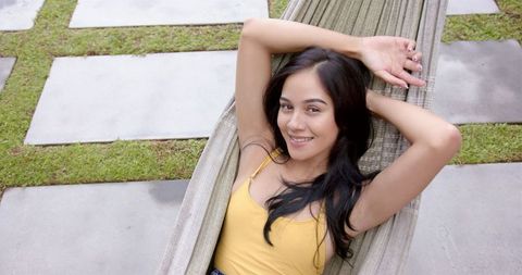 Relaxed Young Woman Lounging Outdoors on Sunny Day