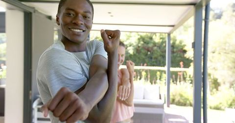 Smiling Man Stretching Near Poolside Patio for Wellness
