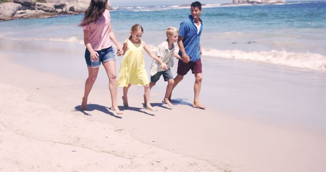 Family running on the beach in slow motion