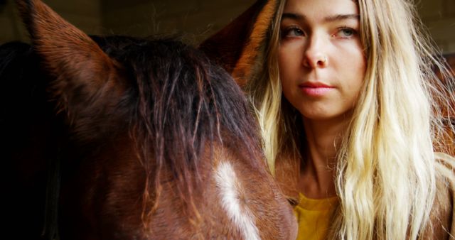 Young woman with long blonde hair bonding with horse in ranch stable - Download Free Stock Images Pikwizard.com