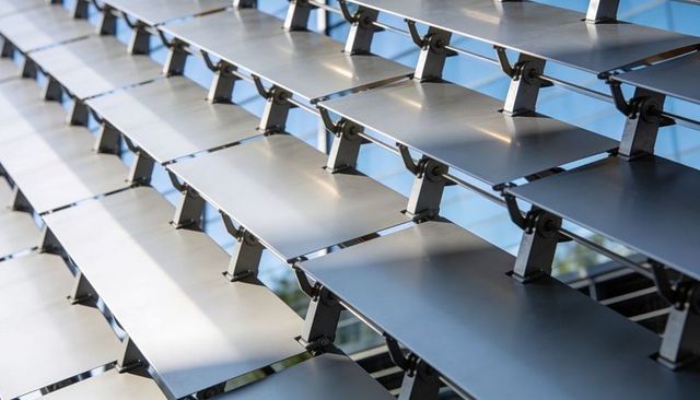 Adjustable metal louver facade panels creating repeating diagonal shading pattern
