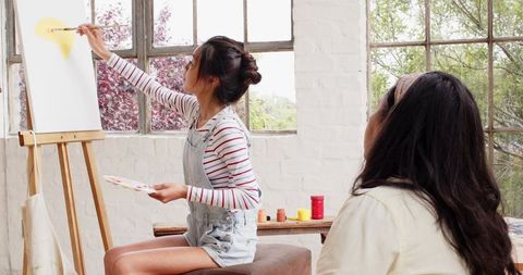 Art Student Learning Under Guidance of Mentor in Sunlit Studio