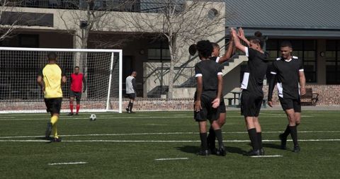 Soccer Players Strategizing on Green Turf during Match