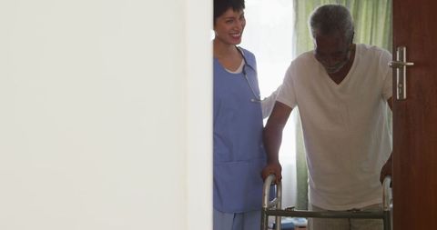 Doctor Assisting Senior Man with Walker at Retirement Home