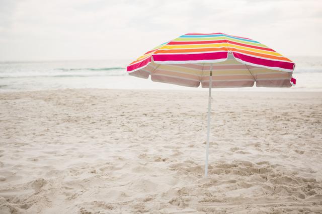 Multi-color striped beach umbrella at tropical sand beach