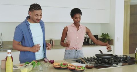 Friends preparing burgers in modern kitchen setting