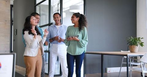 Diverse Team Celebrating Work Success in Modern Office