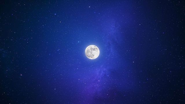 Full moon illuminating starry night sky with purple nebula