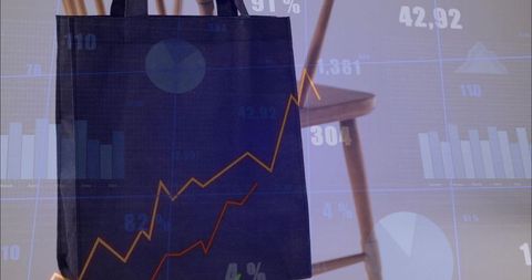Hanging dark navy tote bag showing creases with wooden chair and financial chart overlay