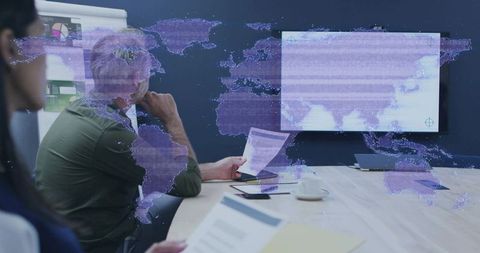 Executive team analyzing global data with digital world map overlay during strategic presentation