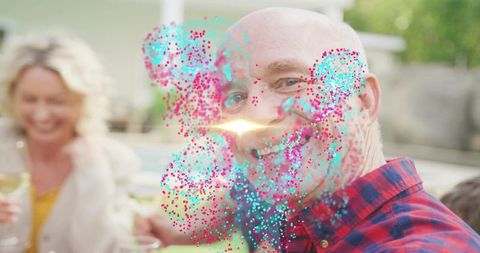 Multigenerational family celebrating on backyard patio by pool with colorful confetti burst
