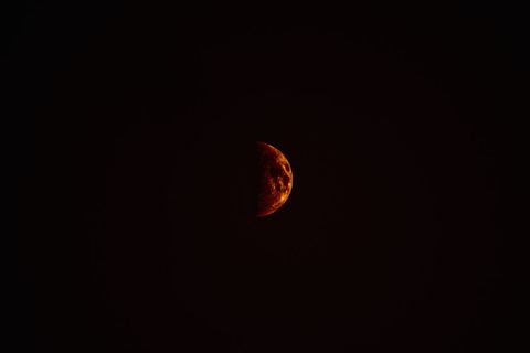 Half red moon in dark night sky
