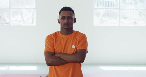 Confident Teenage Judoka in Orange Shirt in Gym Setting
