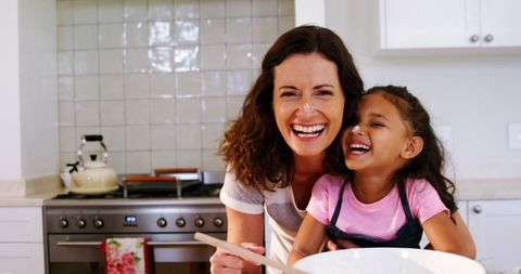 Mother and Daughter Joyfully Baking Together in Cozy Kitchen